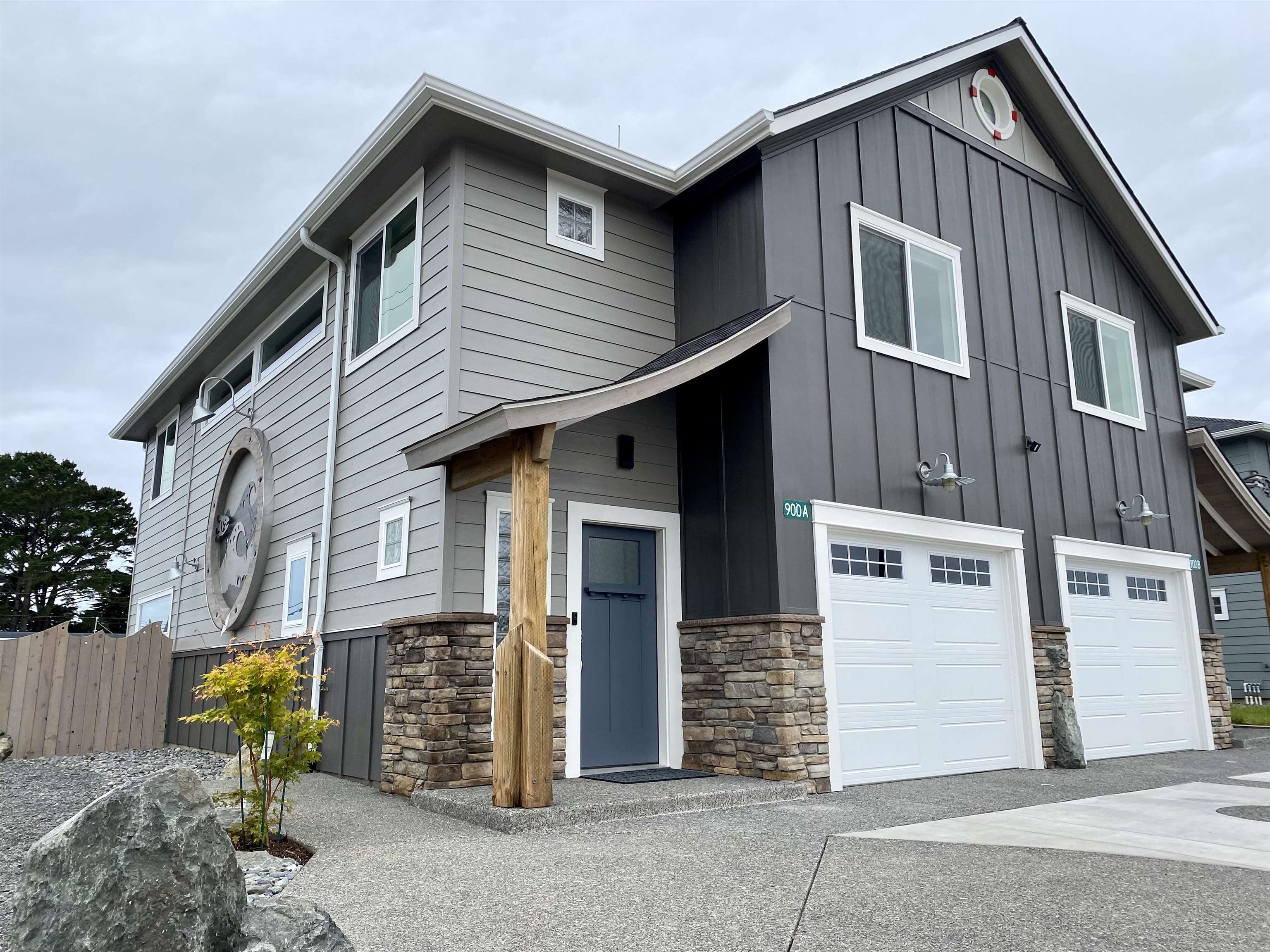 A modern board-and-batten custom home with stone accents and a sculptural timber entry